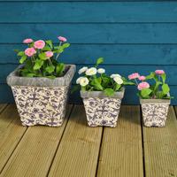 aged ceramic square flower pots in blue by fallen fruits