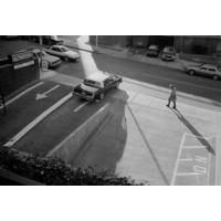 Man Walking Past Parking Lot by Michael Ormerod