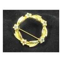 sphinx gold tone floral wreath brooch